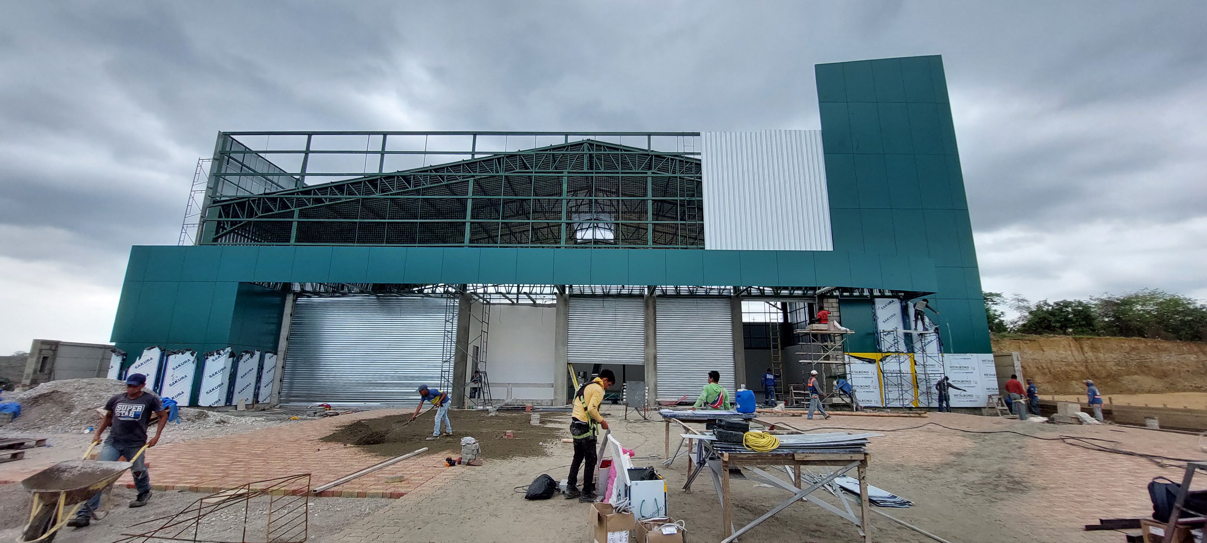 Fachada con puertas enrollables y trabajadores