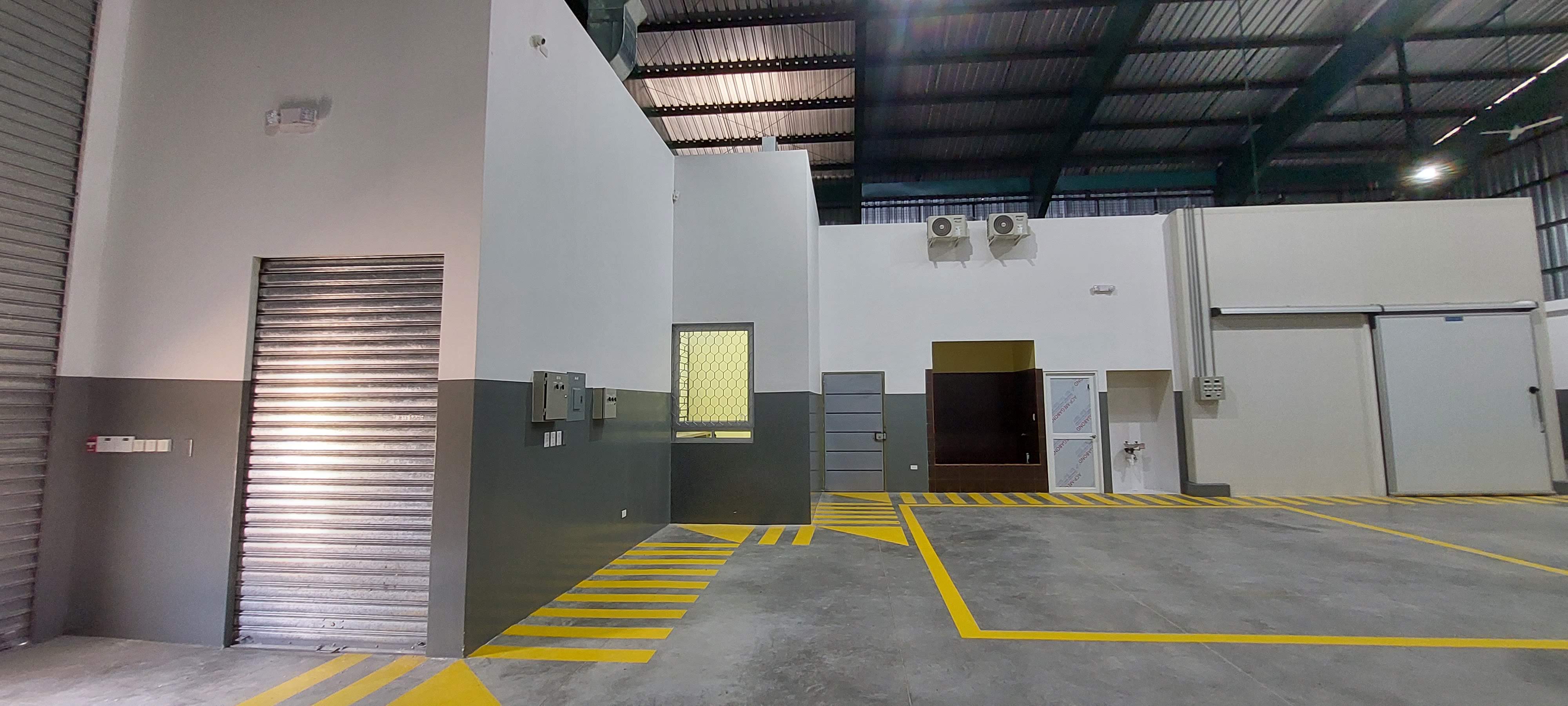 Interior con puerta enrollable y senalizacion amarilla