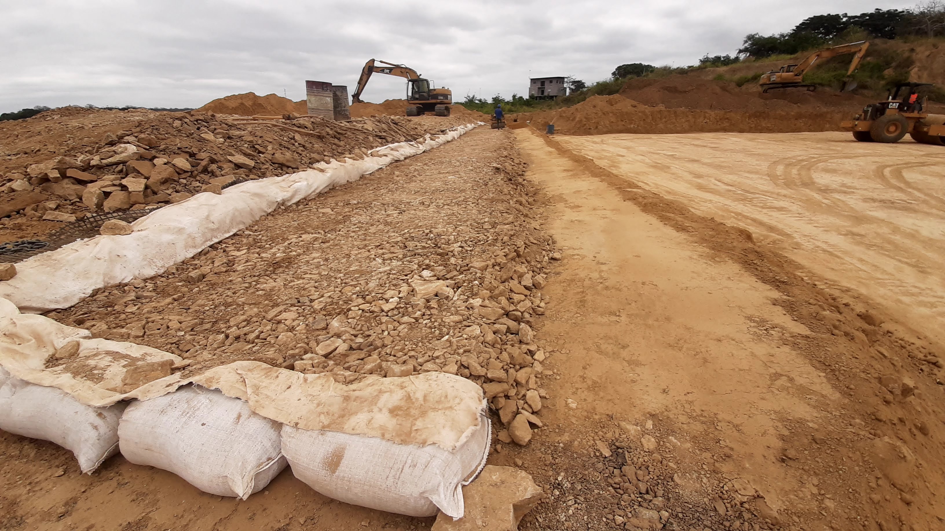 Escollera con sacos y geomalla, excavadora al fondo