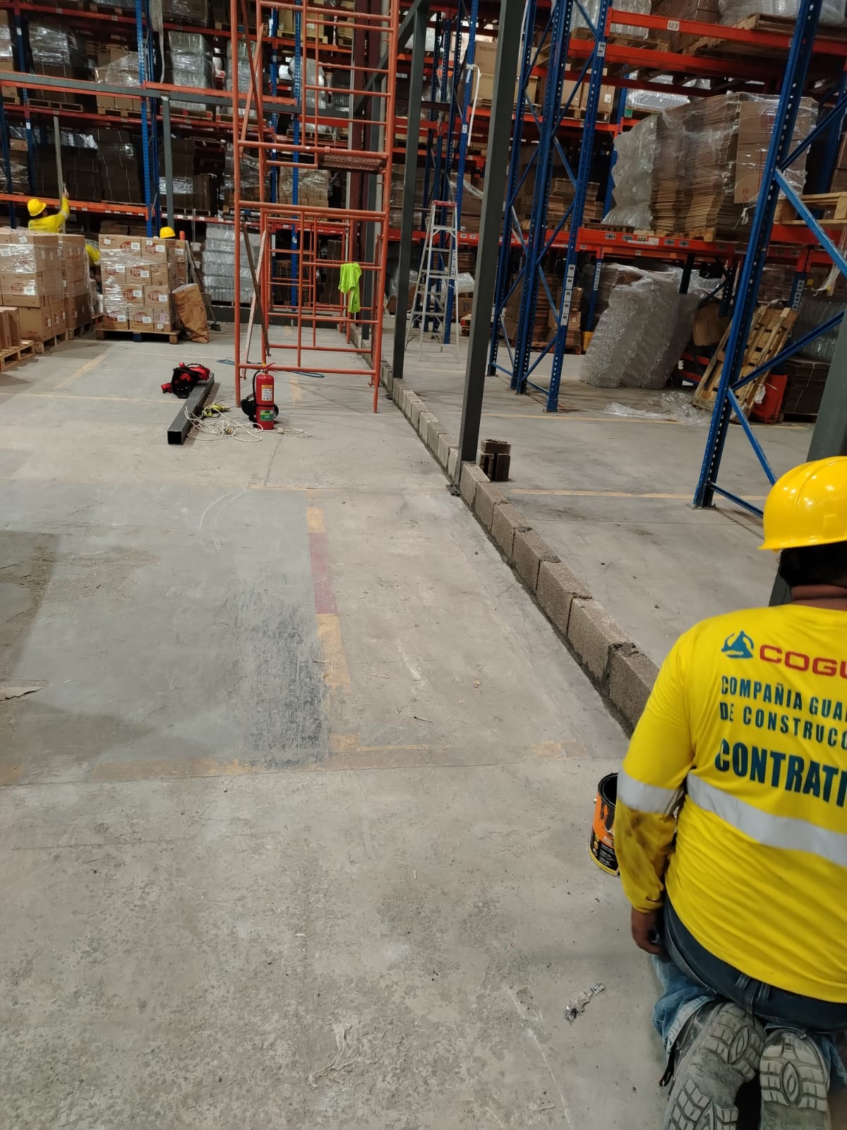 Trabajador COGUCO inspeccionando bodega con racks