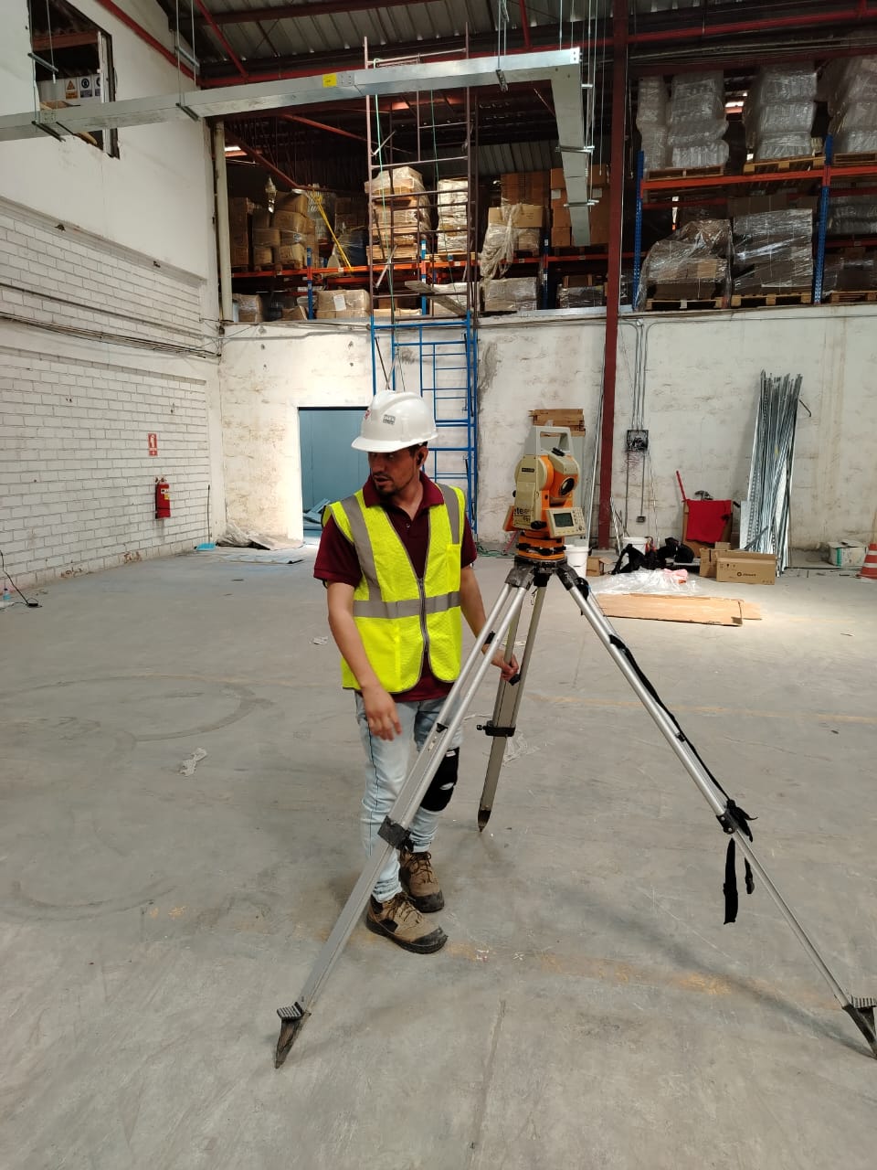Topógrafo con estación total en bodega