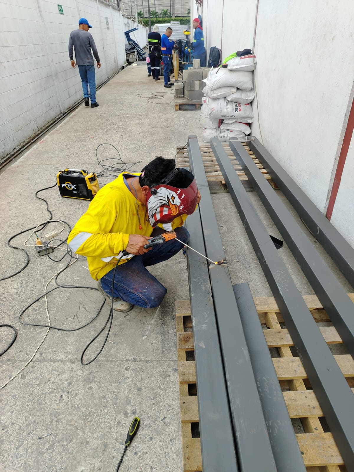 Soldador trabajando en vigas metálicas