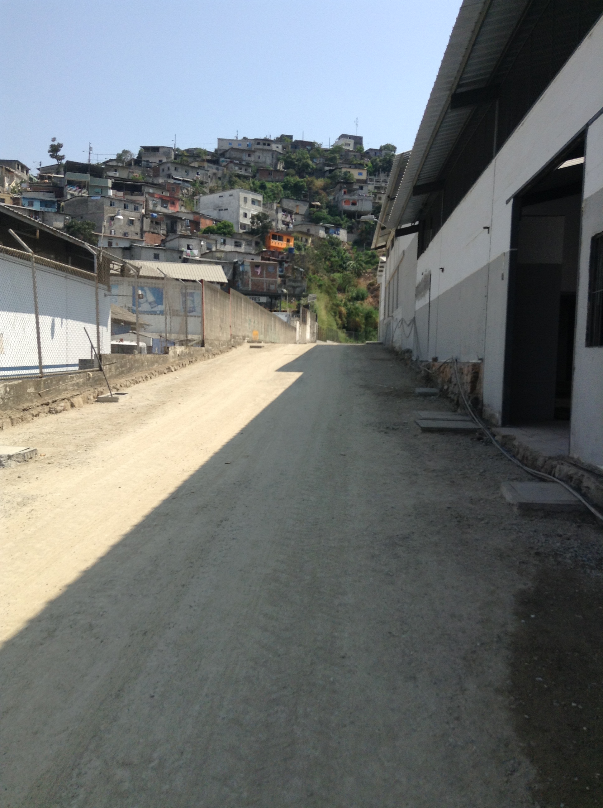 Acceso exterior entre bodegas con cerro al fondo