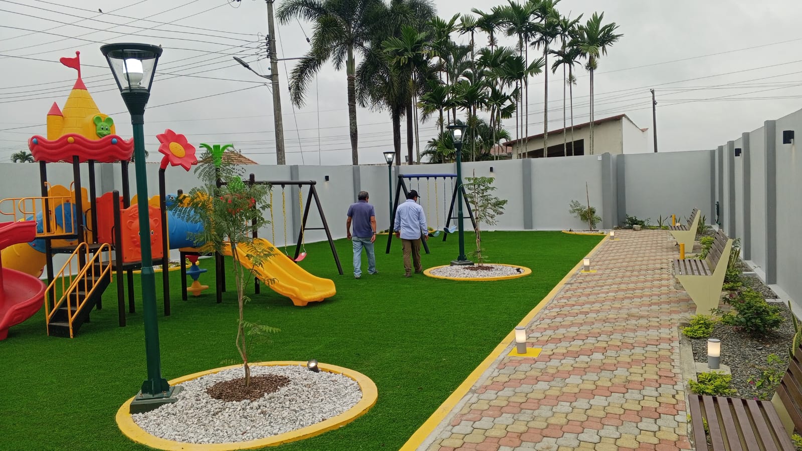 Area de juegos infantiles con cesped sintetico y columpios