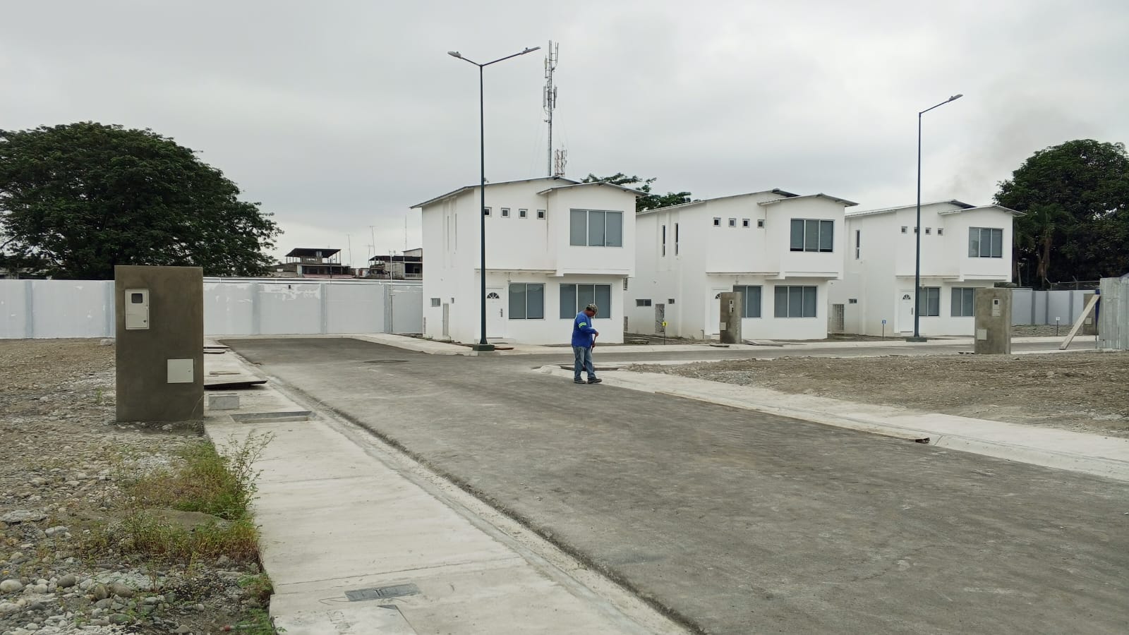 Villas blancas de 2 pisos con calle y alumbrado publico