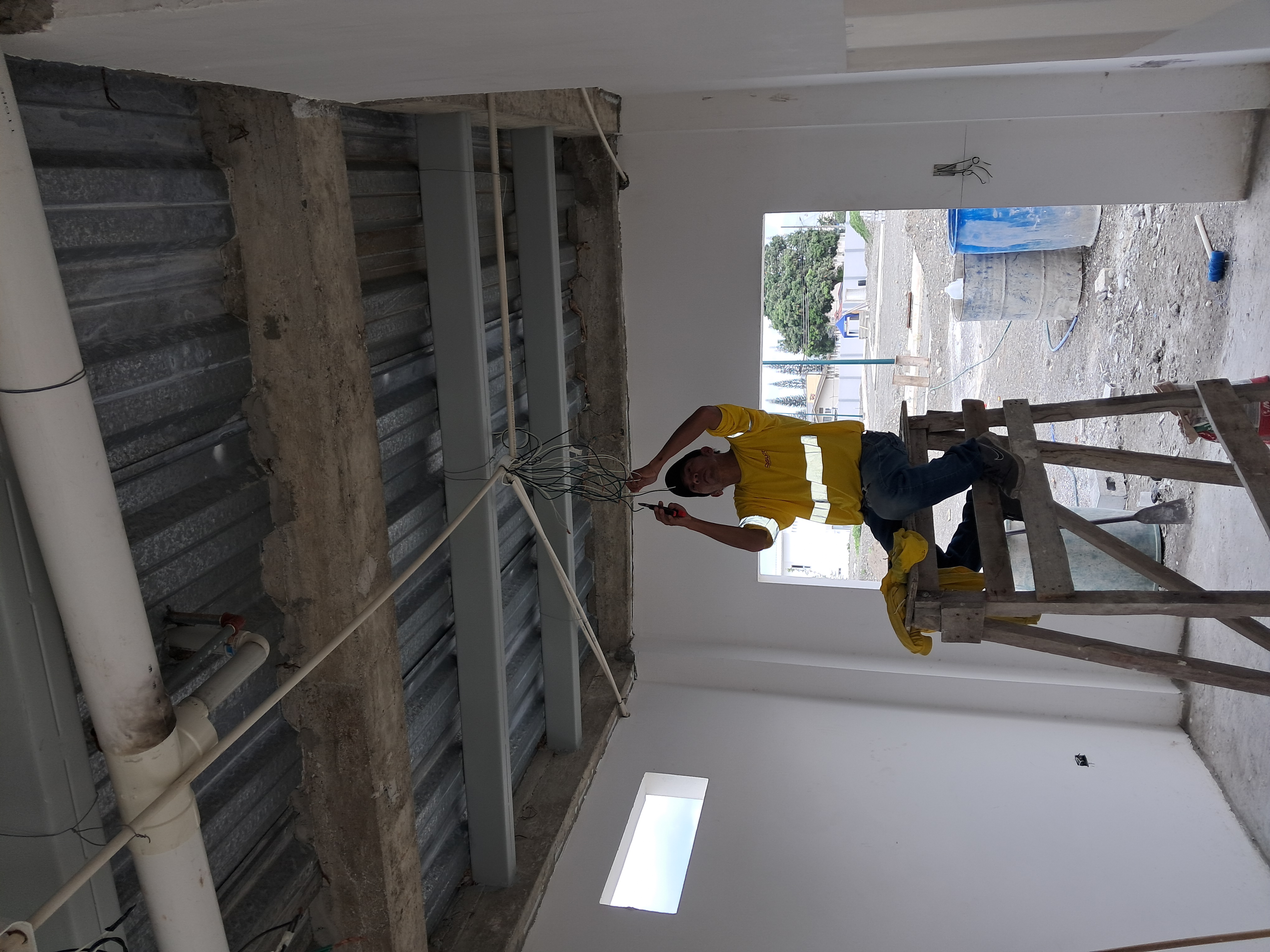 Trabajador realizando instalacion electrica en techo