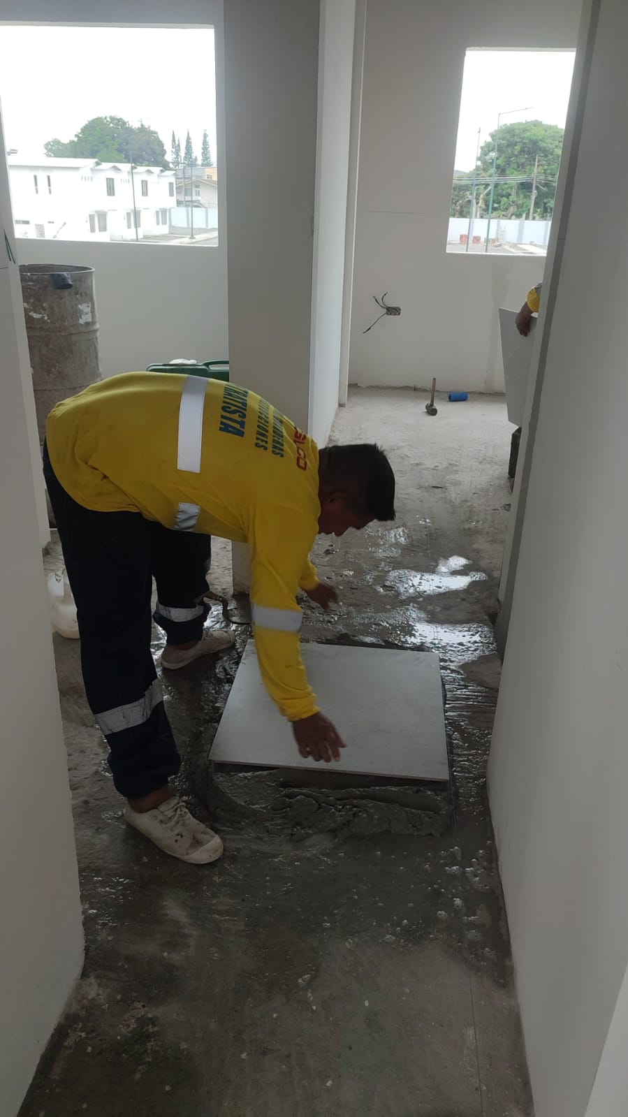 Trabajador COGUCO instalando porcelanato en piso
