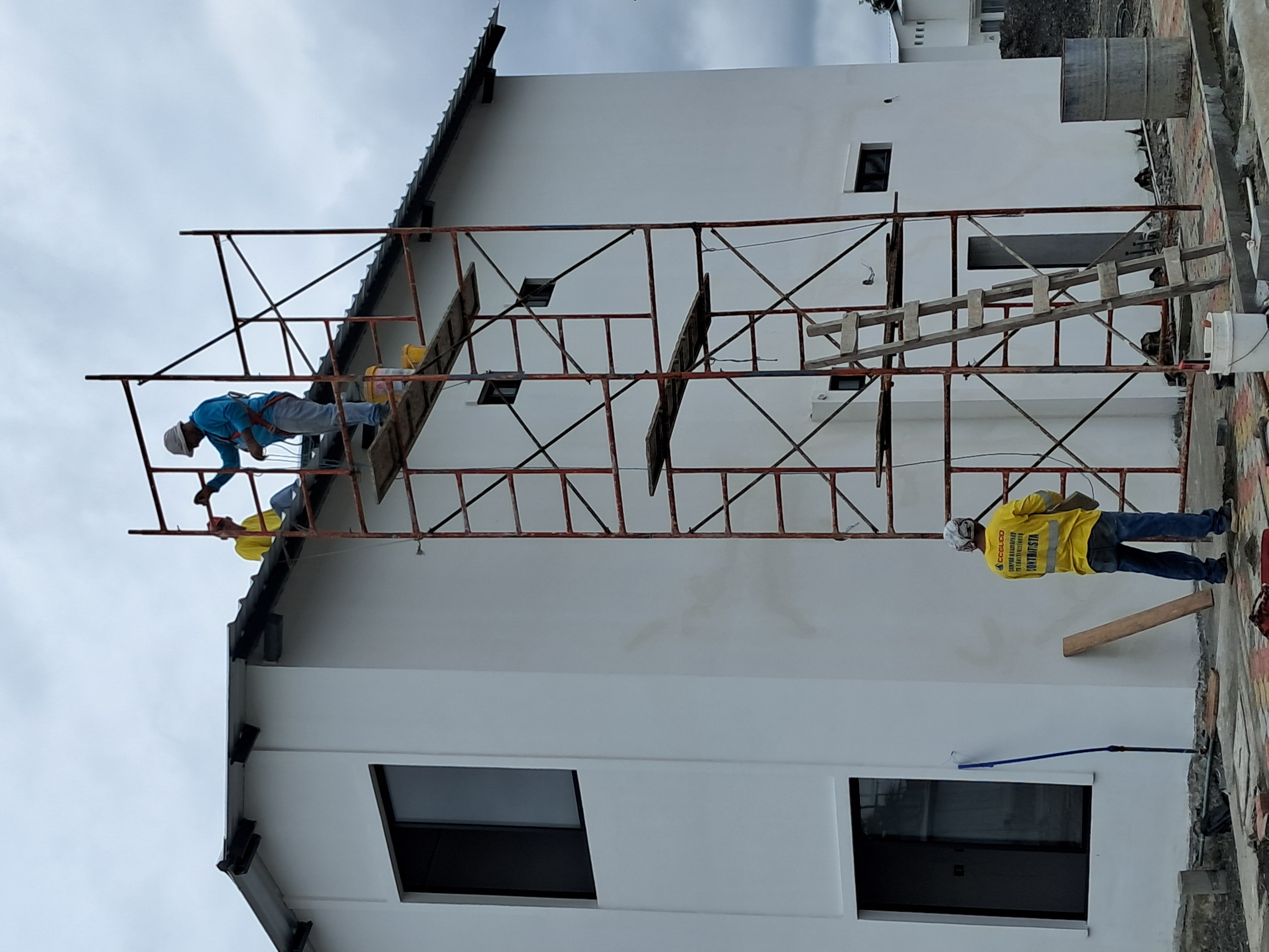 Trabajadores COGUCO pintando fachada con andamio