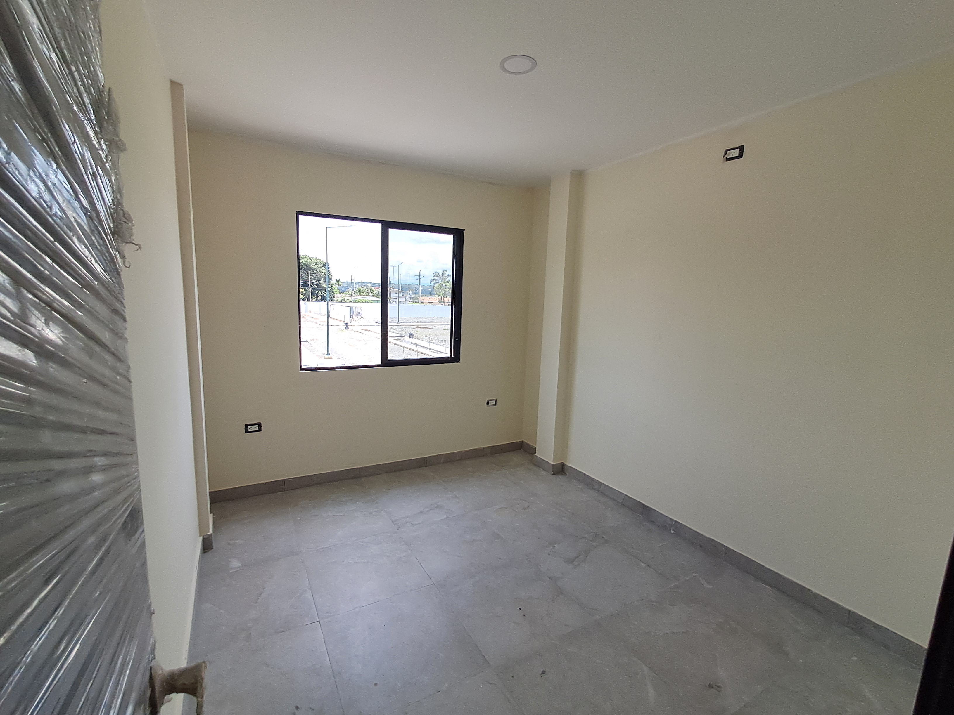 Dormitorio con piso porcelanato y ventana negra